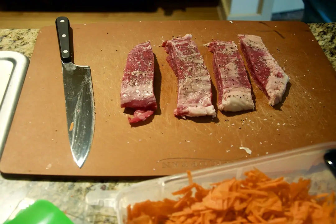 Close-up of a professional chef knife slicing meat