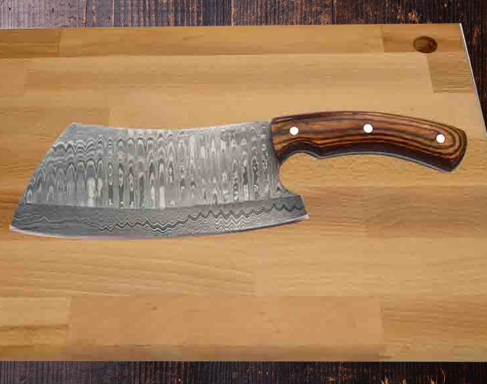 A large, 6" Damascus steel blade chef's knife with a wavy pattern and an ergonomic wooden handle with three rivets rests on a light-colored cutting board. The CARLIN Damascus Cleaver by Faneema Cutlery, featuring a razor-sharp edge and a comfortable ergonomic handle, is set on a dark wooden surface.