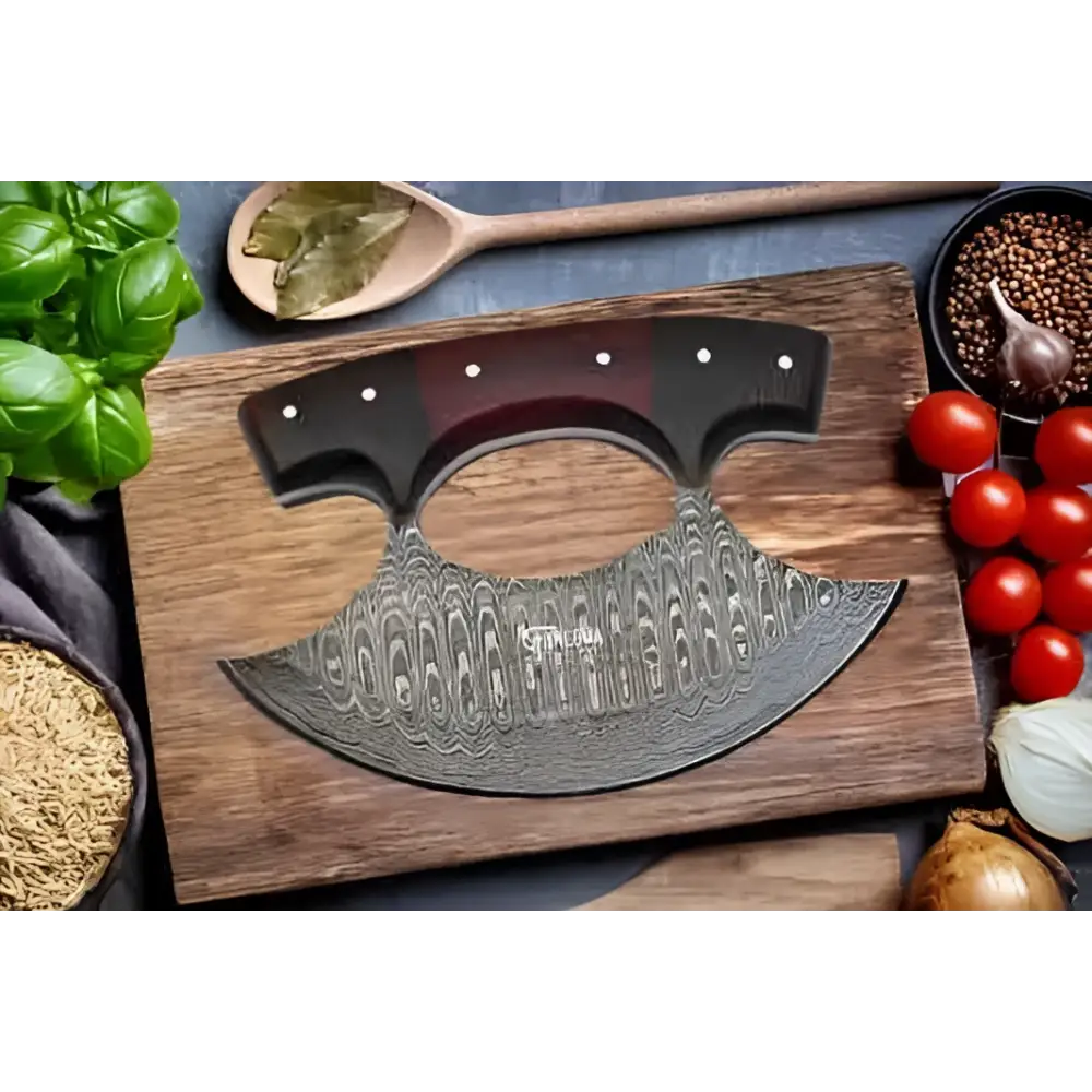 Curved damascus steel faneema ulu knife with wood handle on cutting board