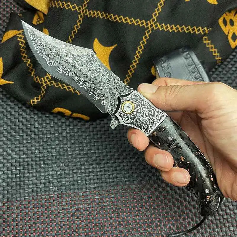 Hand holding stylish Damascus folding knife with carbon fiber handle