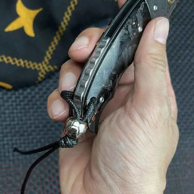 Black carbon fiber folding knife with stylish skull pendant handle