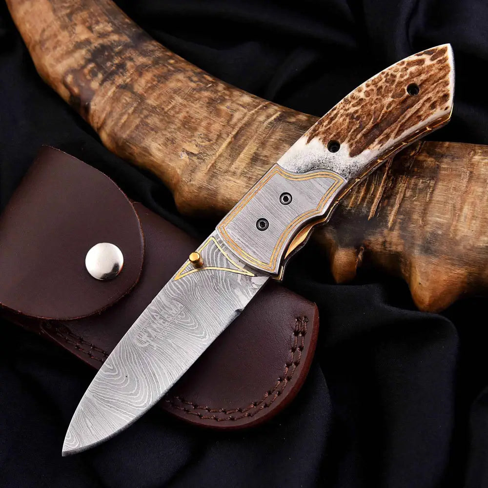 Damascus steel antler folding knife with gold accents