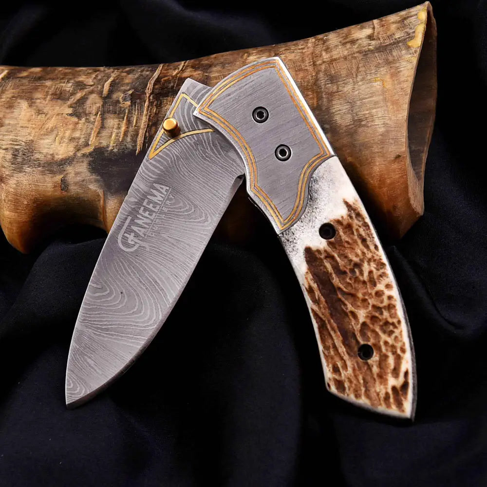 Sleek Damascus steel folding knife with antler handle