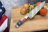 Faneema Cutlery Texas Damascus steel knife chef knife with patriotic handle on cutting board with vegetables